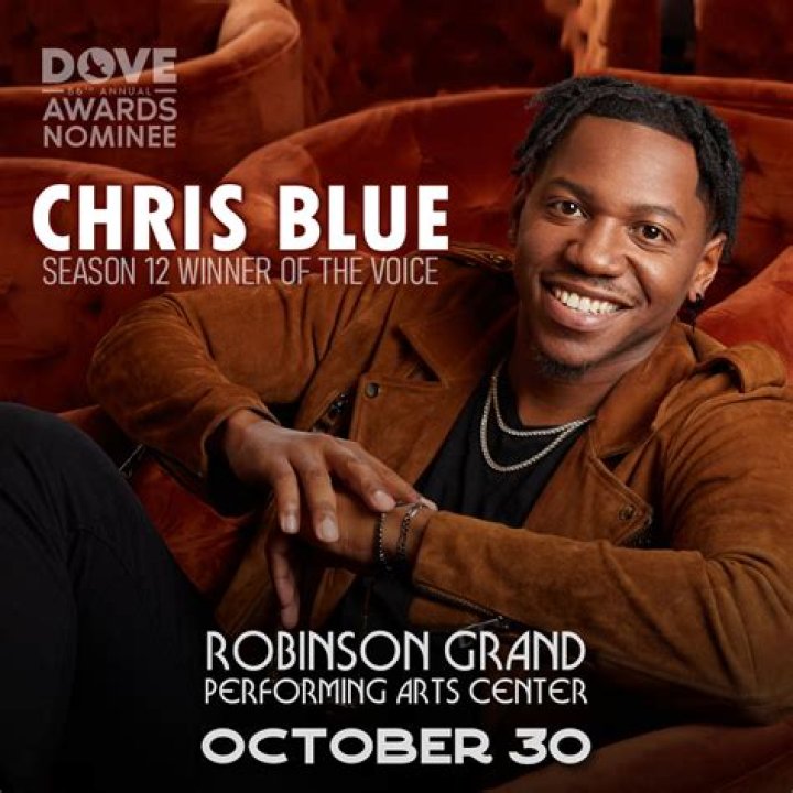 Chris in a blue check shirt by lakeside.