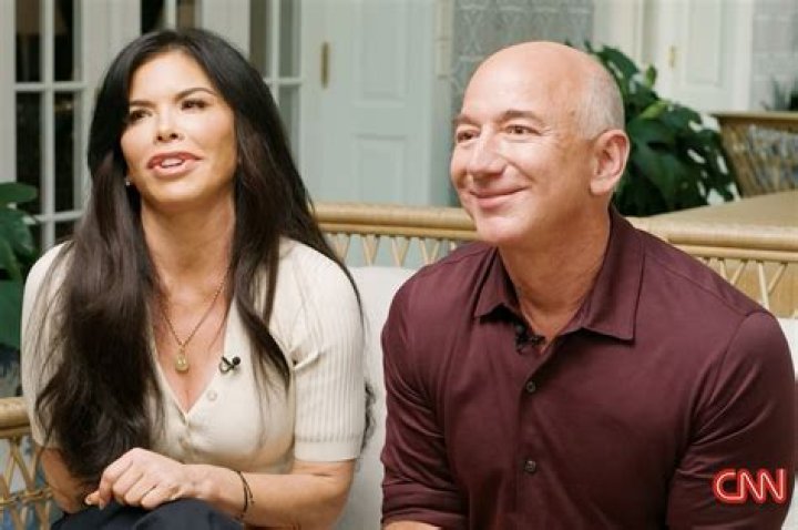 Jeff Bezos is eating a burger in the picture.