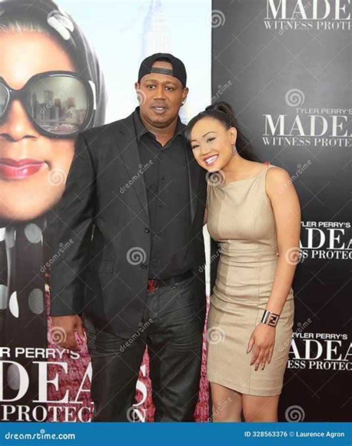 Percy Robert Miller Sr. in a white checked suit and black shades.