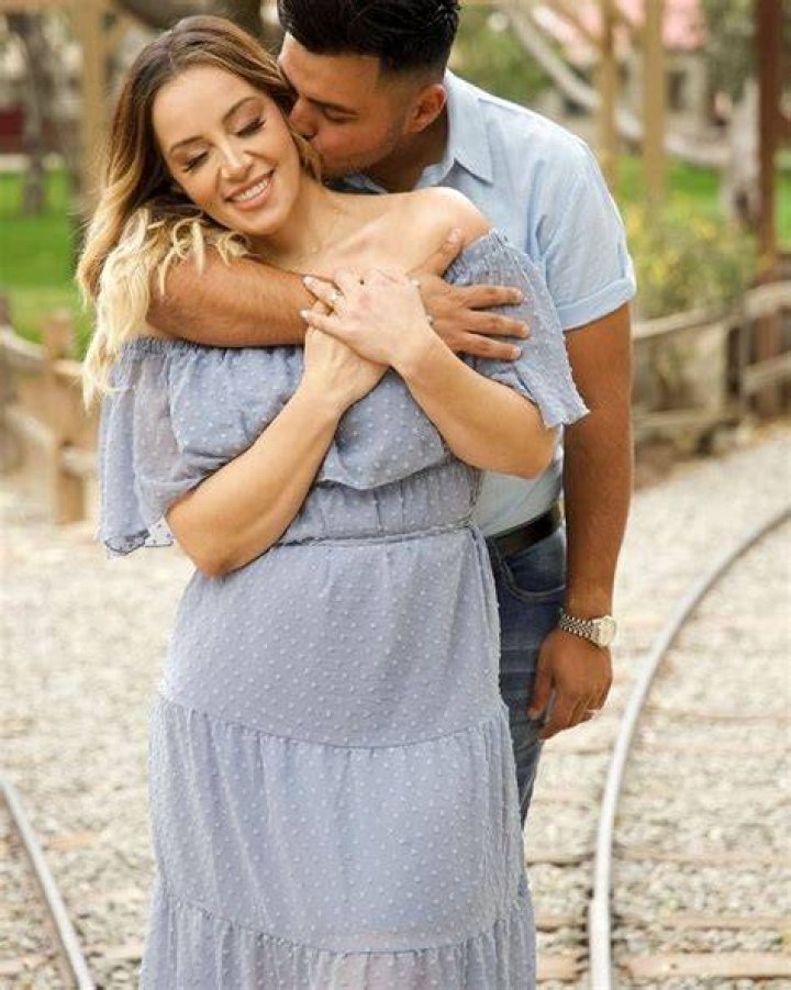 Rosie Amelia Rivera posing with her husband by wearing blue cloth.
